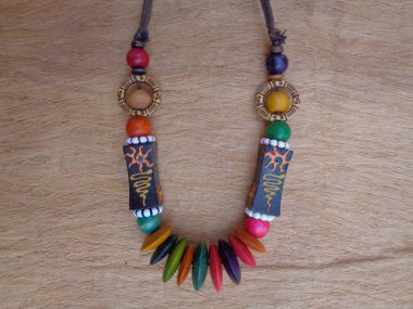 Kahverengi arka planı olan tahta bir kolye. Ahşap arka plandaki kolye..