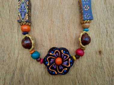 Kahverengi arka planı olan tahta bir kolye. Ahşap arka plandaki kolye..