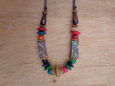 Kahverengi arka planı olan tahta bir kolye. Ahşap arka plandaki kolye..