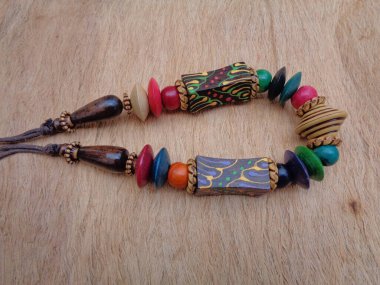 Kahverengi arka planı olan tahta bir kolye. Ahşap arka plandaki kolye..