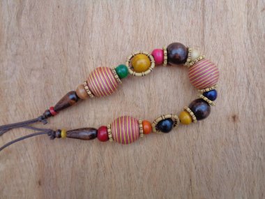 Kahverengi arka planı olan tahta bir kolye. Ahşap arka plandaki kolye..