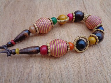 Kahverengi arka planı olan tahta bir kolye. Ahşap arka plandaki kolye..