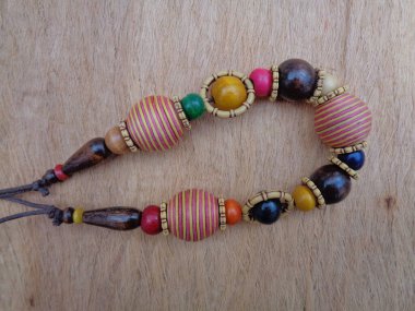 Kahverengi arka planı olan tahta bir kolye. Ahşap arka plandaki kolye..