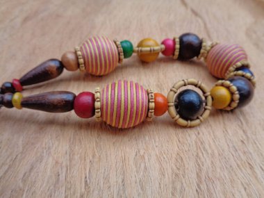 Kahverengi arka planı olan tahta bir kolye. Ahşap arka plandaki kolye..