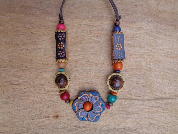 Kahverengi arka planı olan tahta bir kolye. Ahşap arka plandaki kolye..