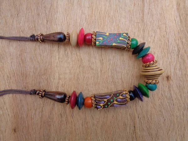 Wooden necklace with brown background. The necklace on the wooden background.