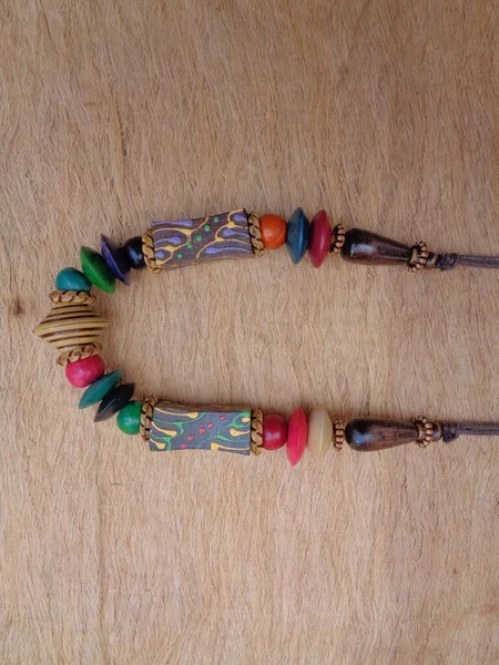 Kahverengi arka planı olan tahta bir kolye. Ahşap arka plandaki kolye..