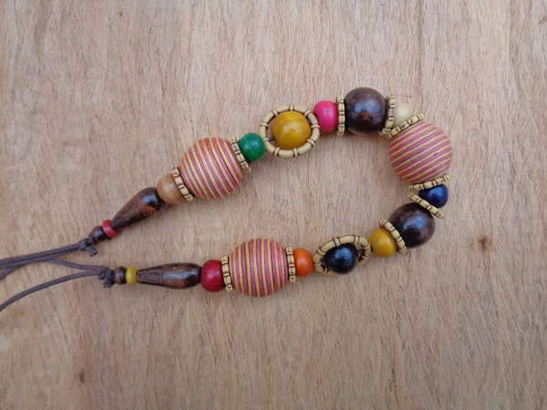 Kahverengi arka planı olan tahta bir kolye. Ahşap arka plandaki kolye..