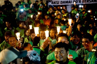 Çevrimiçi motosiklet taksi sürücüleri (ojek online) birlikte dua ediyorlar. Arkadaşları için dayanışma.