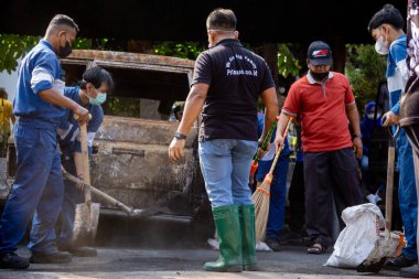 İnsanlar yangından sonra çevreyi temizlemek için birlikte çalışırlar..