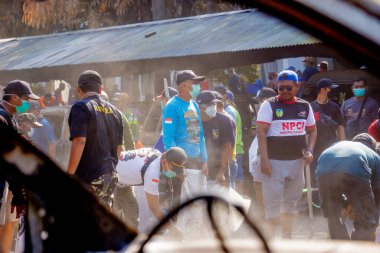 İnsanlar yangından sonra çevreyi temizlemek için birlikte çalışırlar..