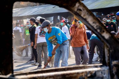İnsanlar yangından sonra çevreyi temizlemek için birlikte çalışırlar..
