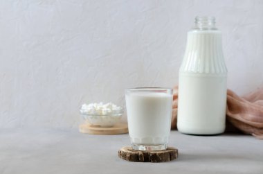 Bardakta ev yapımı mayalanmış içecek kefir, süzme peynir, beyaz arka planda. Ekşi süt içeceği, maya mayası mayası, bağırsak sağlığı konsepti. Modaya uygun yiyecek ve içecekler.