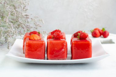  Beyaz tabakta çilekli tatlı. Kırmızı jöleli çilekli mus. Sağlıklı tatlılar, yakın plan..