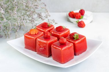  Beyaz tabakta çilekli tatlı. Kırmızı jöleli çilekli mus. Sağlıklı tatlılar, yakın plan..