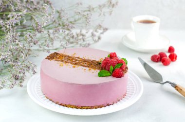 Beyaz arka planda beyaz bir tabakta ahudududulu kek. Yakın plan. Karamel serpiştirilmiş fıstıklı. Vejetaryen, vejetaryen tatlı.