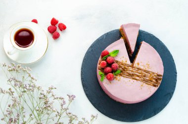  Ahududulu kek, beyaz arka planda, tahta tabakta dilimlenmiş. Bir fincan çayla. Yakın plan. Düz yatıyordu.