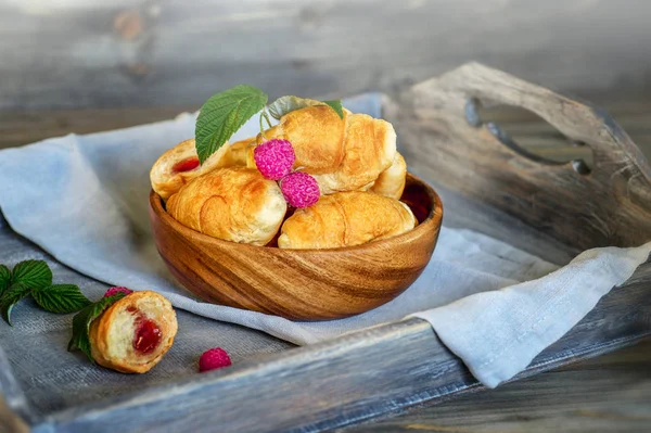 Croissants met frambozen op een houten dienblad. Het concept van een w — Stockfoto