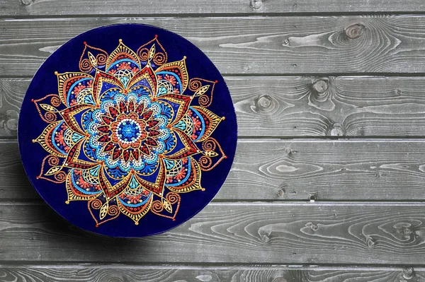 Dekorative Keramikteller handbemalt Punktemuster mit Acrylfarben auf einem grauen Holzgrund. Kopierraum. Stockbild