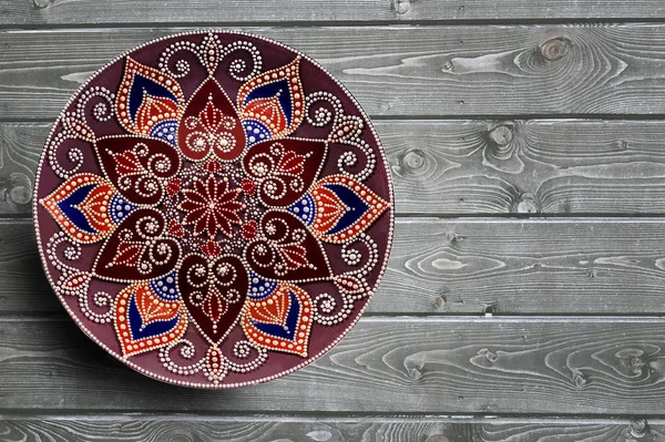 Dekorative Keramikteller handbemalt Punktemuster mit Acrylfarben auf einem grauen Holzgrund. Kopierraum. Stockbild