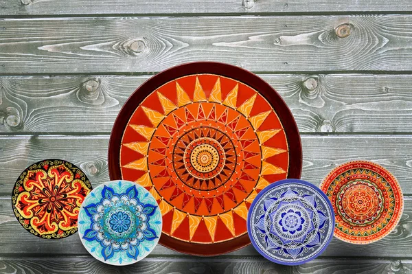 Conjunto de placas de cerámica decorativas pintadas a mano patrón de puntos con pinturas acrílicas sobre un fondo de madera gris. Copiar espacio . — Foto de Stock