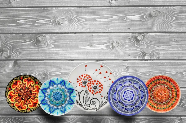 Set van decoratieve keramische platen handgeschilderde dot patroon met acrylverf op een grijze houten achtergrond. Ruimte kopiëren. — Stockfoto
