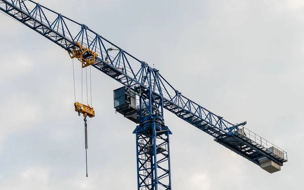 A tall tower crane rising high into the sky at a construction site, symbolizing the power of modern engineering and the dynamic progress of the building process in an urban environment. 