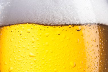 Köpüklü ve damlacıklı soğuk bira bardağına yakın çekim. Seçici odak.