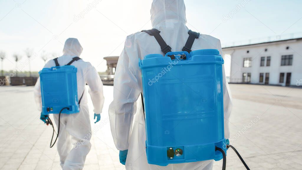 Save Lives. Sanitization and cleaning of the city due to the emergence of the Covid19 virus. Specialized team in protective suits and masks with backpack of pressurized spray disinfectant