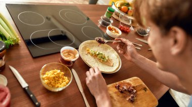 Hepsi çok lezzetli. Yemek pişirme sürecini kapat. Adam mutfakta sağlıklı yemek hazırlıyor. Vejetaryenlik, sağlıklı yiyecekler, diyet, evde kalma kavramı