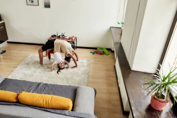 Mujer afroamericana niñera y niña linda caucásica que tiene entrenamiento en casa. Educación infantil, actividades de ocio, concepto de cuidado de niños —  Fotos de Stock