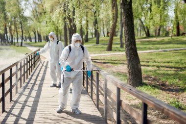 Temizlik ekibi. Covid19 virüsünün ortaya çıkmasından dolayı şehir parkının temizlenmesi, temizlenmesi ve dezenfekte edilmesi. Koruyucu giysiler ve maskeler konusunda uzman ekip iş başında.