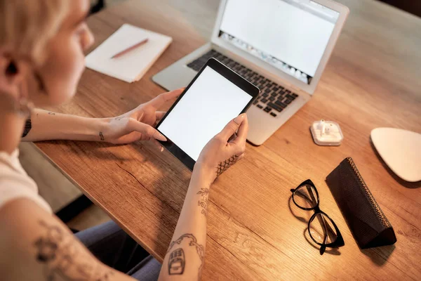 Tecnologie digitali al lavoro. Giovane donna carina con tatuaggi utilizzando tablet digitale mentre seduto sul suo posto di lavoro — Foto Stock