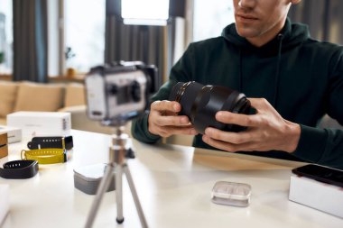 Mükemmel Resmin Kalbi. Genç erkek teknoloji blogcusu video blogu ya da video blogu kaydediyor. Ev stüdyosundaki yeni kamera lensleri hakkında. Bloglama, Evden Çalışma kavramı