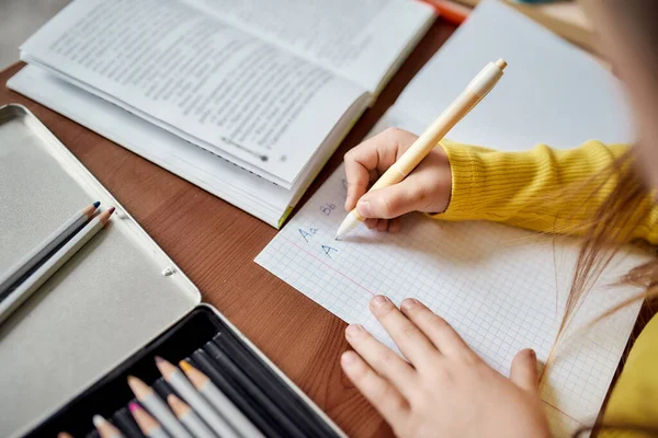 Αλφάβητο. Κοντινό πλάνο των χεριών του καυκάσιου μικρού κοριτσιού. Το παιδί γράφει, μαθαίνει να γράφει γράμματα χρησιμοποιώντας στυλό. — Φωτογραφία Αρχείου