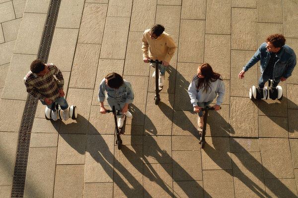 Желаю приключений. Радостные друзья катаются на скутерах и сегвеях
