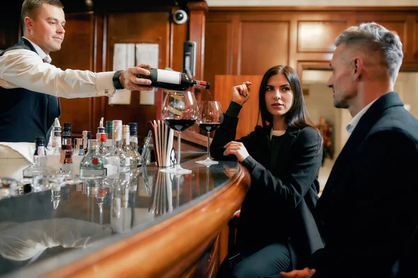 Hora del vino. Dos personas de negocios ocasionales en un bar del hotel por la noche tomando dos copas de vino tinto después del check-in —  Fotos de Stock