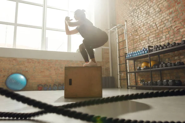 Entregar boa saúde. Mulher esportiva usando caixa de plyo ao ter treino no ginásio industrial — Fotografia de Stock