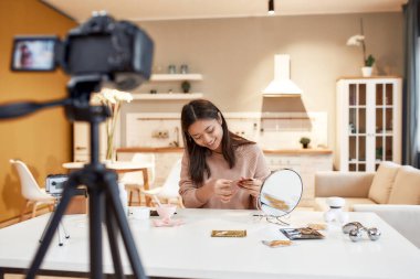 Sosyal alanını çerçevele. Genç bayan blogcu, güzellik blogu için cilt rutiniyle ilgili özel bir video kaydediyor. Vlogger göz bandı testi, sosyal ağ için video kaydı