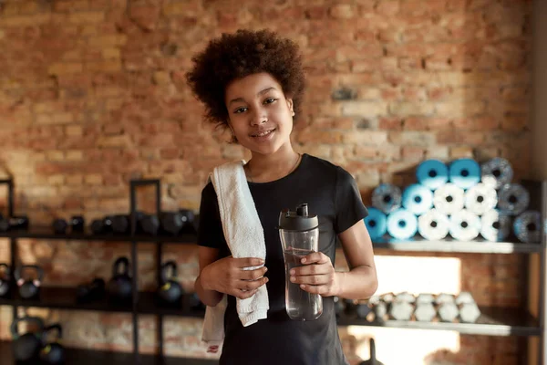 Felice ragazzo afroamericano sorridente alla macchina fotografica dopo aver fatto allenamento in palestra. Sport, stile di vita sano, educazione fisica — Foto Stock