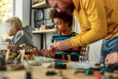 Rüyaları gerçeğe dönüştürmek. Genç teknisyenler robot yapıyor. Kök robotik dersinde erkek bir öğretmenle birlikte elektrik kablosu setinde çalışıyorlar. Çocuklar için icatlar ve yaratıcılık