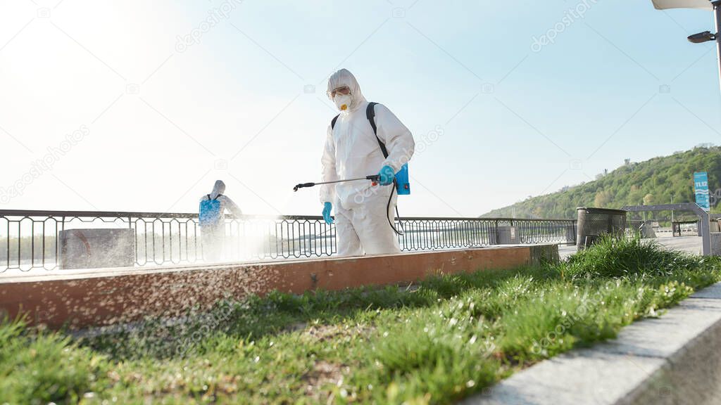 Make your change for good. Sanitization, cleaning and disinfection of the city due to the emergence of the Covid19 virus. Specialized team in protective suits and masks at work near the riverside