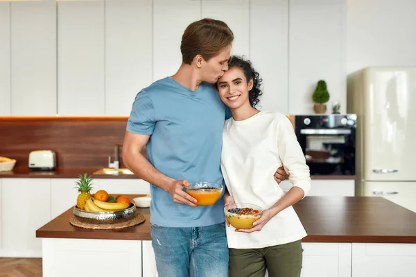 Πρόσεχε το σώμα σου. Ευτυχισμένο ζευγάρι, χορτοφάγοι κρατώντας μπολ smoothie, ενώ στέκεται στην κουζίνα μαζί. Χορτοφαγία, υγιεινά τρόφιμα, διατροφή, μείνετε στο σπίτι έννοια — Φωτογραφία Αρχείου