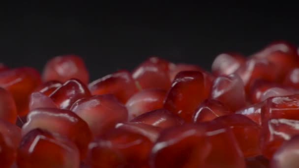 Verse granaatappel in granen. Super macro shot van glanzende sappige granaatappel zaden op een donkere achtergrond — Stockvideo
