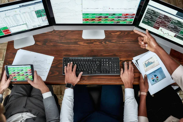 Strategiczna ścieżka. Najlepszy widok biznesmenów, handlowców pracujących, korzystających z papierów i tabletów, siedzących przy biurku przed wieloma monitorami komputerowymi. Ręce na klawiaturę. — Zdjęcie stockowe