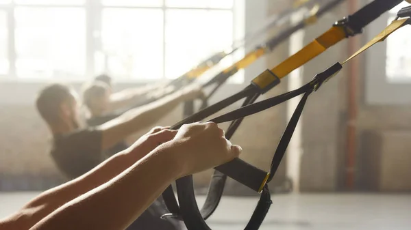 Tecnología fitness. Cierre de manos. Mujer haciendo ejercicios de entrenamiento de fitness en el gimnasio industrial. Push-up, concepto de entrenamiento en grupo —  Fotos de Stock