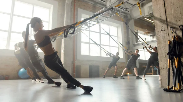 Más fuerte que ayer. Foto completa de hombres y mujeres haciendo ejercicios de entrenamiento de fitness en el gimnasio industrial. Push-up, concepto de entrenamiento en grupo —  Fotos de Stock