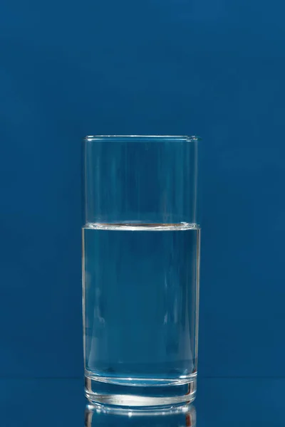 Glas drinkwater geïsoleerd op een blauwe achtergrond — Stockfoto