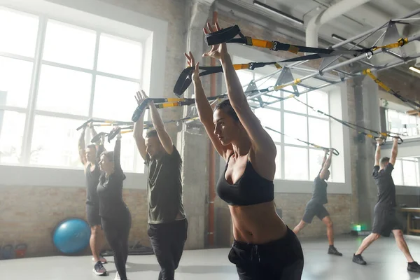 Mergem mai departe. Portretul bărbaților și femeilor care fac exerciții de fitness la sala de sport industrială. Push-up, concept de antrenament de grup — Fotografie, imagine de stoc