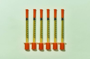 Diabet için insülin şırıngalarının üst görüntüsü ışık arkaplanı üzerinde dikey olarak izole. Enjeksiyon ilacı konsepti